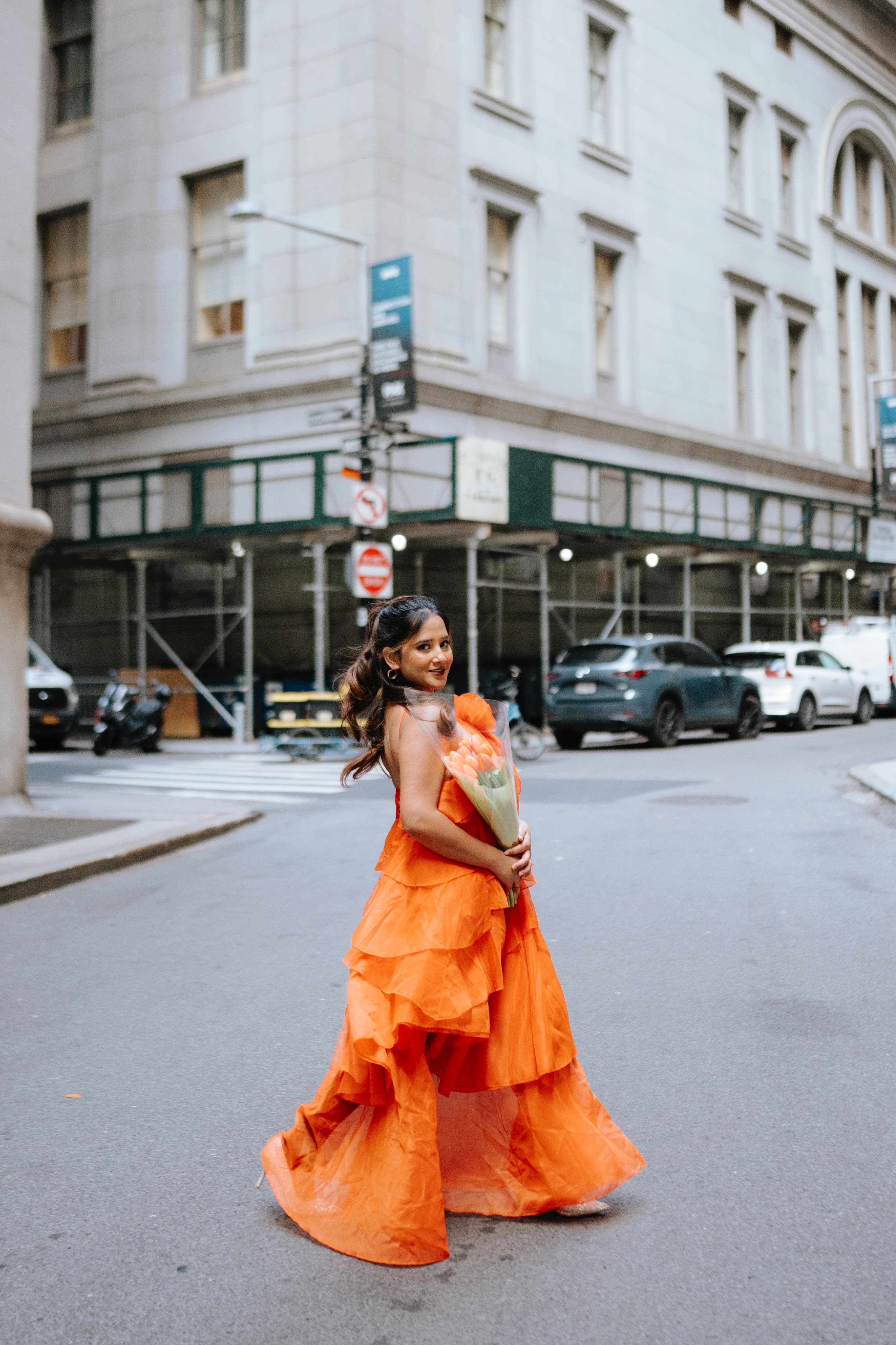 Maitreyi Tiwari in an orange gown on a city street